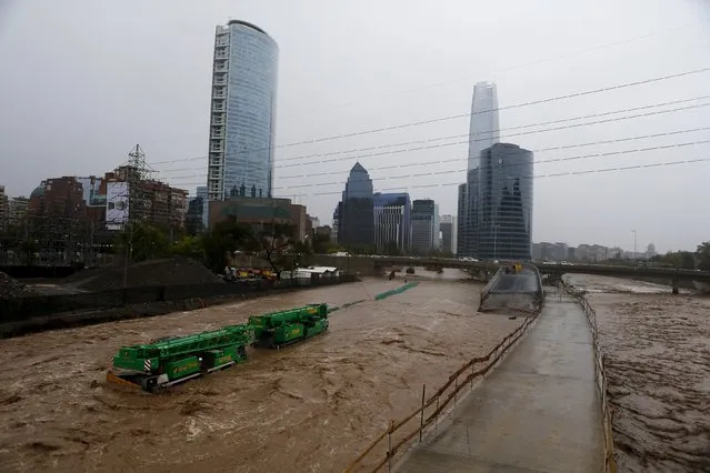 Crane are seen on a flooded street in Santiago, April 17, 2016. (Photo by Ivan Alvarado/Reuters)