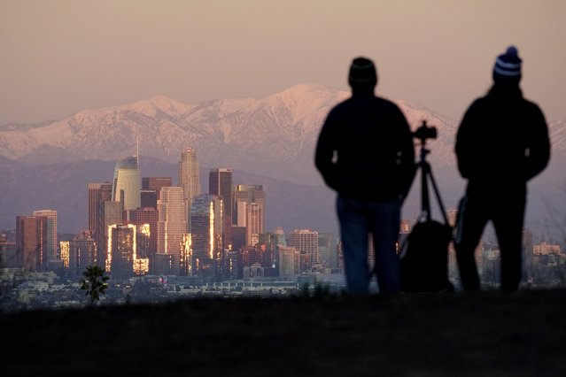 Photographers look at snow covered mountains behind downtown Los Angeles Sunday, January 2, 2022, from Kenneth Hahn State Recreation Area in Los Angeles (Photo by Mark J. Terrill/AP Photo)