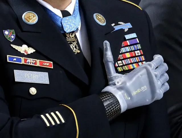 Medal of Honor recipient Sgt. 1st Class Leroy Petry stands with his prosthetic hand over his heart and wears his Medal of Honor during the “Pledge of Allegiance” at the Capitol in Olympia, Wash., during a ceremony to honor Petry and other recipients of the Medal of Honor who are from Washington state, on April 2, 2014. (Photo by Ted S. Warren/Associated Press)