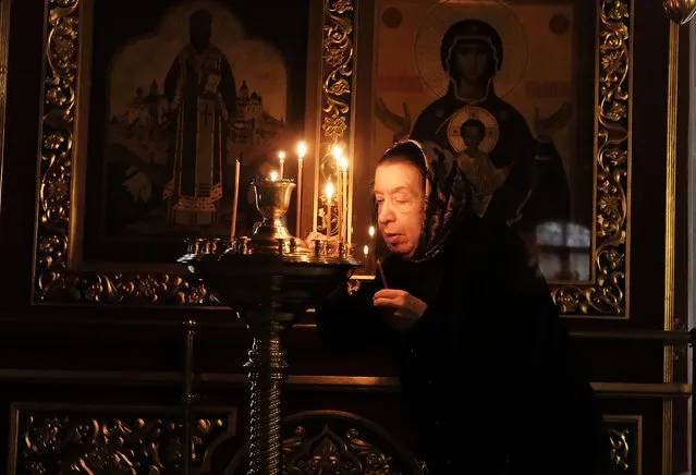 A woman lights a prayer candle at an Orthodox church on March 6, 2017 in Moscow, Russia. (Photo by Spencer Platt/Getty Images)