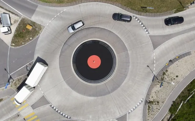 A photo taken with a drone shows cars driving in a roundabout, designed as a giant vinyl turntable, in Lyss, Switzerland on 27 May 2019. (Photo by Peter Klaunzer/EPA/EFE/Rex Features/Shutterstock)