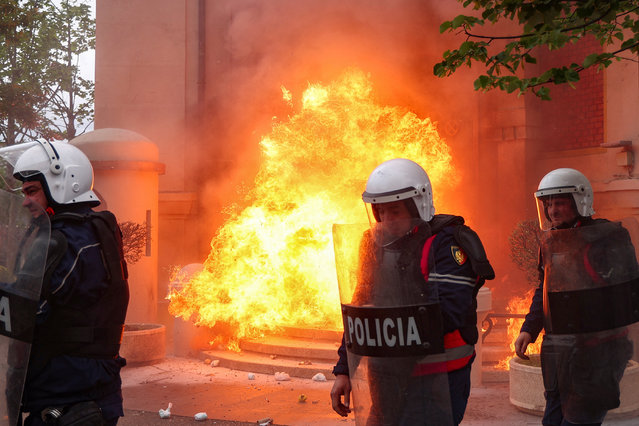 Police officers react as supporters of the opposition hurl Molotov cocktails at the mayor's office, accusing him of corruption, in Tirana, Albania, on April 19, 2024. (Photo by Florion Goga/Reuters)