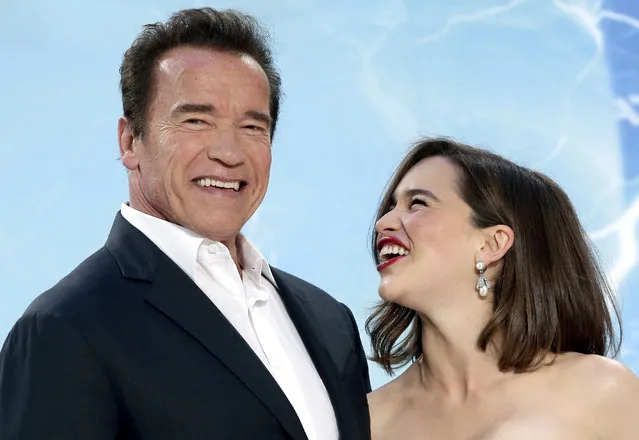 Actor Arnold Schwarzenegger, left, and actress Emilia Clarke joke as they pose for the photographers prior to the Europe premiere of the movie 'Terminator: Genisys' in Berlin, Germany, Sunday, June 21, 2015. (AP Photo/Michael Sohn)