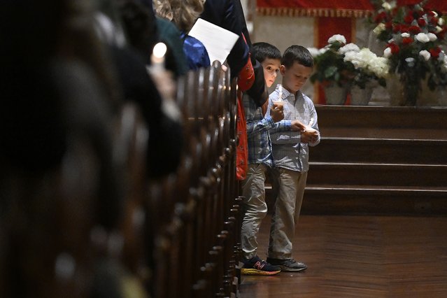 Two boys hold candles during a Pentecost Vigil at Blessed Michael McGivney Parish at St. Mary's Church, Saturday, May 18, 2024, in New Haven, Conn. The Eucharistic Procession from St. Mary's Church is one of four pilgrimage routes crossing the country and converging at the National Eucharistic Congress in Indianapolis, July 16. (Photo by Jessica Hill/AP Photo)