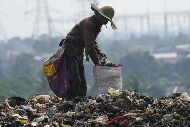 A  ragpicker looks for recyclable items in a pile of garbage at a landfill in Depok on the outskirts of Jakarta, Indonesia. Friday, May 10, 2024. (Photo by Tatan Syuflana/AP Photo)