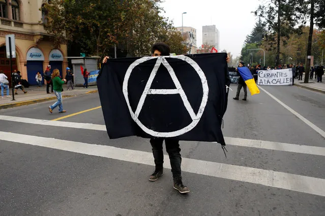 A student protester holds an anarchist flag during a demonstration to demand changes in the education system in Santiago, Chile, May 5, 2016. (Photo by Ivan Alvarado/Reuters)