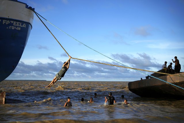 Children play with the ropes of a ship docked on a beach in Parika, Guyana, Sunday, June 9, 2024. (Photo by Ramon Espinosa/AP Photo)