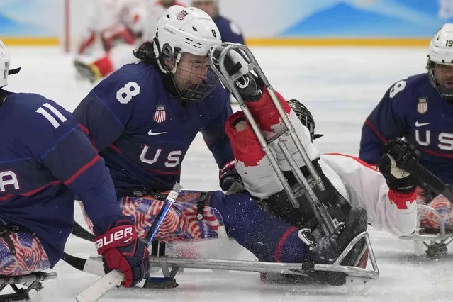Jack Wallace of the United States, left, and China's Wang Zhidong collide as they battle for the puck during their para ice hockey semifinal match at the 2022 Winter Paralympics, Friday, March 11, 2022 in Beijing. (Photo by Dita Alangkara/AP Photo)