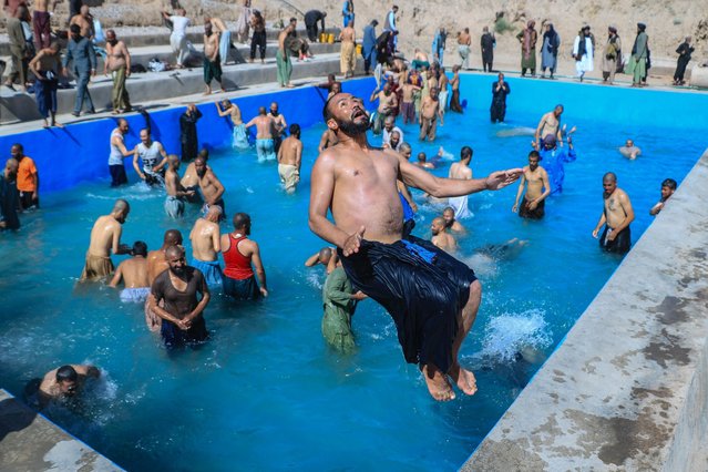 Afghan men cool off in a pool before their release from a drug rehabilitation and treatment centre, after the completion of their treatment in Herat on June 10, 2024. (Photo by Mohsen Karimi/AFP Photo)