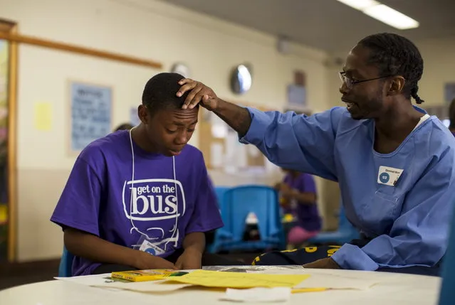 Inmate Donnell Moore touches the head of his son Donnell Moore during a special Father's Day visit part of the “Get On The Bus” program at California Men's Colony in San Luis Obispo, California May 30, 2015. (Photo by Mario Anzuoni/Reuters)