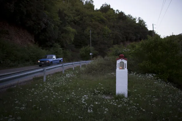 In this photo taken on Wednesday, April 26, 2017, a candle is lit in a roadside shrine near the village of Lalas, in the Peloponnese region of southern Greece. (Photo by Petros Giannakouris/AP Photo)