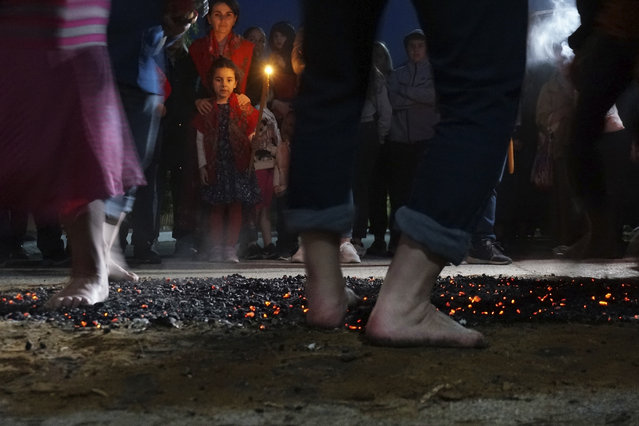 Firewalkers dance across a bed of burning coals in a ritual in honor of St. Constantine in the village of Lagkadas, Greece on Monday, May 22, 2023. Firewalking is the most spectacular and public of these annual rituals that also include dancing with icons, prayer, and shared meals by associations of devotees of the Christian Orthodox saint called “anastenaria” that have held similar celebrations for centuries. (Photo by Giovanna Dell'Orto/AP Photo)