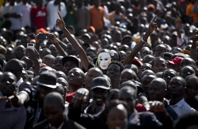 An opposition supporter wears a white mask as he and others attend a rally for opposition leader Raila Odinga to commemorate Madaraka Day, when Kenya attained internal self-rule in 1963, at Uhuru Park in Nairobi, Kenya Wednesday, June 1, 2016. (Photo by Ben Curtis/AP Photo)