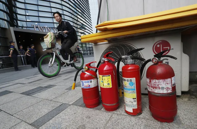 Fire extinguishers are placed near a building where the Japanese embassy is located in Seoul, South Korea, Friday, July 19, 2019. South Korean police say a man has set himself on fire in front of the Japanese Embassy in Seoul amid rising trade disputes between Seoul and Tokyo. (Photo by Ahn Young-joon/AP Photo)