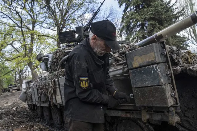 A Ukrainian serviceman repairs a tank after fighting against Russian forces in Donetsk region, eastern Ukraine, Wednesday, April 27, 2022. (Photo by Evgeniy Maloletka/AP Photo)