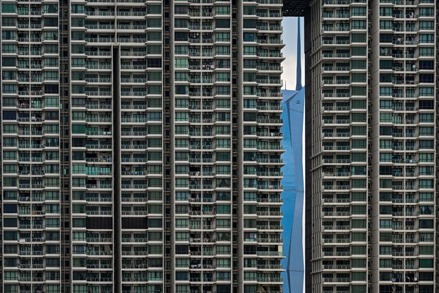 Warisan Merdeka Tower (KL118) (R), the second tallest building in the world, is pictured through a residential building in Kuala Lumpur on May 15, 2024. (Photo by Mohd Rasfan/AFP Photo)