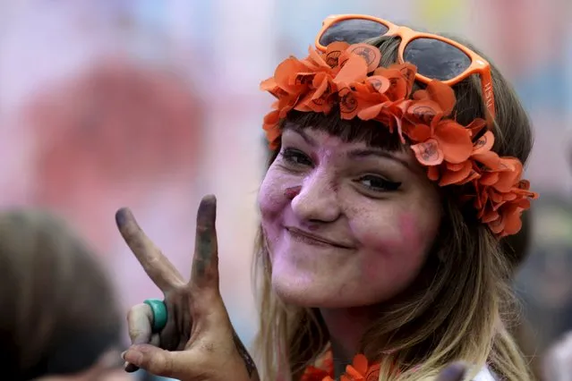 A woman reacts to the camera during the Holi festival, or the Festival of Colors, in Riga, Latvia, August 1, 2015. Primarily observed in India, the ancient Hindu religious festival has spread to other regions of the world. (Photo by Ints Kalnins/Reuters)