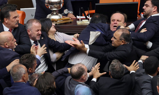 Turkish ruling and opposition lawmakers fight each other after a scuffle between former footballer Alpay Ozalan (unseen), a lawmaker from Erdogan's ruling AKP party and Turksih Workers Party (TIP) deputy Ahmet Sik (unseen) at Grand National Assembly of Turkey in Ankara on August 16,2024. A brawl broke out in Turkey's parliament on August 16, 2024, after lawmakers convened to discuss the status of a jailed opposition figure controversially stripped of his parliamentary immunity earlier this year. They were meeting after the country's constitutional court earlier this month struck down parliament's decision to oust Can Atalay from his parliamentary seat. (Photo by Adem Altan/AFP Photo)