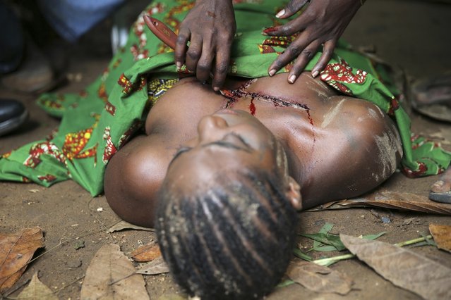 An actress lies on the ground as a makeup artist applies artificial blood to her chest while filming “October 1″, a police thriller directed by Kunle Afolayan, at a rural location in Ilaramokin village, southwest Nigeria, August 24, 2013. (Photo by Akintunde Akinleye/Reuters)
