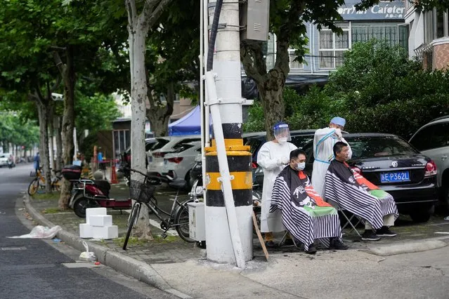 Residents get haircuts on a closed street during lockdown amid the coronavirus disease (COVID-19) pandemic, in Shanghai, China, May 20, 2022. (Photo by Aly Song/Reuters)