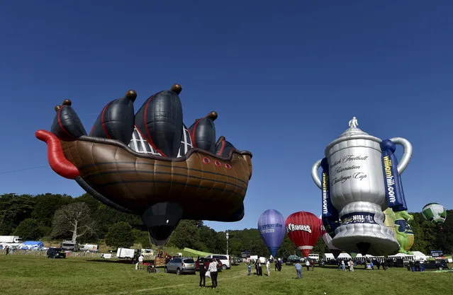 A hot air balloon named “The Ship” (L) is seen tethered during a mass launch at the Bristol International Balloon Fiesta in south west England August 7, 2015. (Photo by Toby Melville/Reuters)
