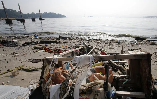 A toy doll is seen on Fundao beach in the Guanabara Bay in Rio de Janeiro March 13, 2014. (Photo by Sergio Moraes/Reuters)