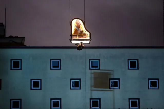 Swiss artist Alain Roche plays the piano hanging from a crane during a concert at a construction site in Munich, Germany, early January 24, 2020. (Photo by Michael Dalder/Reuters)