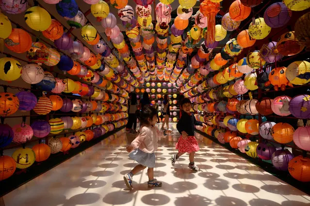 Children play under a lantern installation ahead of the upcoming mid-autumn festival at a shopping mall in Kuala Lumpur on September 10, 2019. (Photo by Mohd Rasfan/AFP Photo)