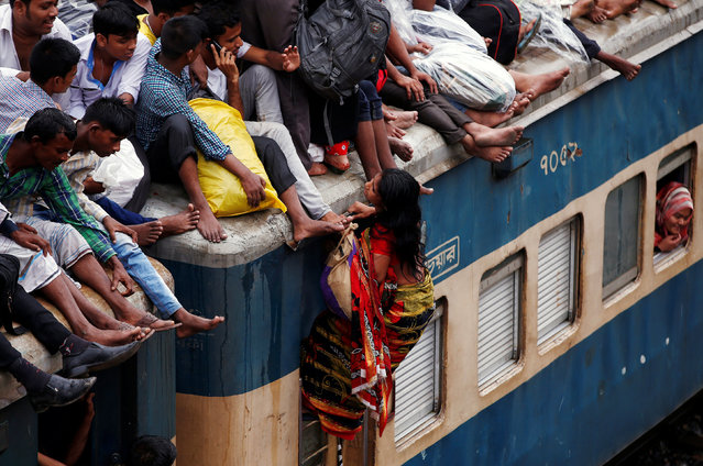 A woman requests others to pull her up on an overcrowded passenger train as they travel home to celebrate Eid al-Fitr festival, which marks the end of the Muslim holy fasting month of Ramadan, at a railway station in Dhaka, Bangladesh, July 5, 2016. (Photo by Adnan Abidi/Reuters)