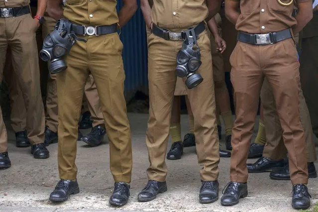 Policemen stand guard during a protest in Colombo, Sri Lanka, Monday, July 11, 2022. (Photo by Rafiq Maqbool/AP Photo)