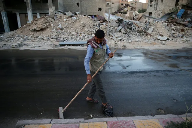 A man cleans a street on the first day of the Muslim holiday of Eid al-Fitr, which marks the end of the holy month of Ramadan, in the rebel held Douma neighborhood of Damascus, Syria July 6, 2016. (Photo by Bassam Khabieh/Reuters)