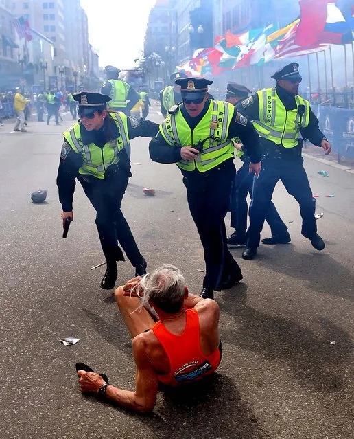 First Place, Domestic News. Photo by John Tlumacki of The Boston Globe, who was also named Photojournalist Of The Year (Large Markets). Boston police officers race toward downed runner Bill Iffrig seconds after the first bomb exploded during the April 15, 2013, Boston Marathon. (Photo by John Tlumacki)