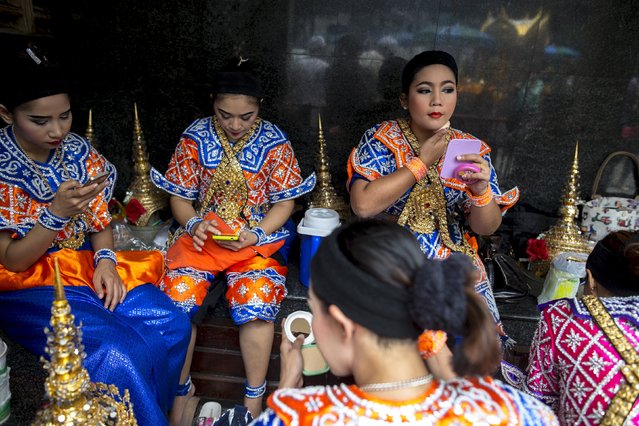 Thai classical dancers touch up their make up before performing at the Erawan shrine, the site of last Monday's deadly blast, in Bangkok, Thailand, August 24, 2015. Nearly a week after a bomb in Thailand killed 20 people, authorities appear no closer to identifying suspects or a motive, with police saying on Sunday a lack of modern equipment was hampering their investigation. (Photo by Athit Perawongmetha/Reuters)
