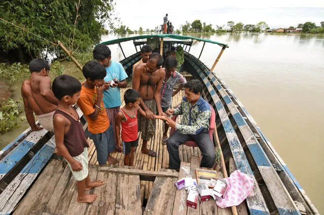 A health official collects blood samples from a boy in a flooded village in Morigaon district in Assam, August 18, 2017. (Photo by Anuwar Hazarika/Reuters)