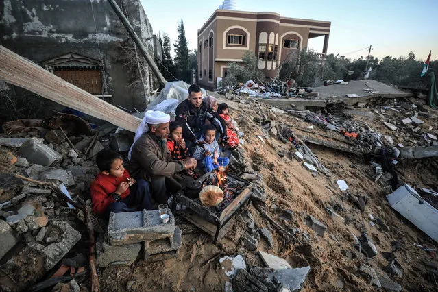 Members of Abu Amre family prepare their meal next to debris of their house which were destroyed in the latest Israeli attack on Gaza, in Gaza City, Gaza on January 10, 2020.17-member Abu Amre family, whose homes were completely destroyed, struggles with the harsh winter conditions. Family members prepare their meals on a a fire while trying to warm up around it. (Photo by Ali Jadallah/Anadolu Agency via Getty Images)