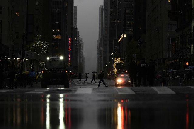 Pedestrians cross Sixth Avenue ahead of the start of the Macy's Thanksgiving Day Parade, Thursday, November 28, 2024, in New York. (Photo by Julia Demaree Nikhinson/AP Photo)