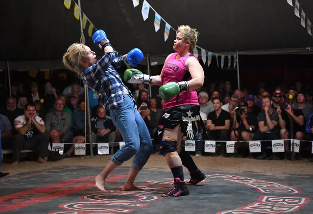 Two women are seen boxing inside the Fred Brophy's Boxing Tent in Birdsville, Australia, 31 August 2017. The Fred Brophy Boxing Troupe sets up their tent and invites members of the crowd to box against Brophy's professional fighters for three rounds during the Birdsville Races. Birdsville is situated on the edge of the Simpson Desert, 1590 kms from Brisbane and its normal population of 115 people swells to a crowd of more than 6000 for its annual horse race. (Photo by Darren England/EPA/EFE)