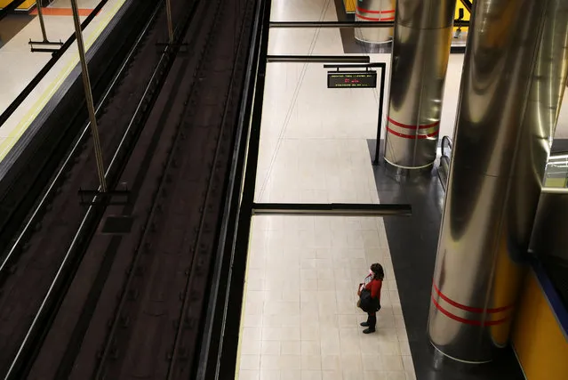 A woman wears a protective face mask at a deserted metro platform during the coronavirus disease (COVID-19) health emergency in Madrid, Spain, March 19, 2020. (Photo by Susana Vera/Reuters)