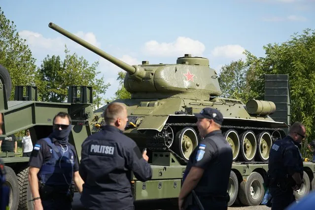 Police officers stand next to a trailer transporting a Soviet T-34 tank which was installed as a monument in Narva, arrived to a military museum in Tallinn, Estonia, Tuesday, August 16, 2022. Estonia's government said Tuesday it has decided to remove a Soviet monument in the border town of Narva, sitting in the Baltic country's Russian-speaking part, with the prime minister saying the reason for the dismantling is that it represents a risk for public order. (Photo by Sergei Grits/AP Photo)