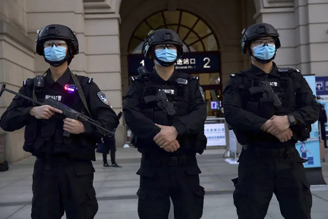 Police officers wearing face masks to protect against the spread of new coronavirus stand guard outside of Hankou train station ahead of the resumption of train services in Wuhan in central China's Hubei Province, Wednesday, April 8, 2020. (Photo by Ng Han Guan/AP Photo)
