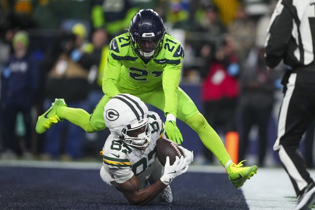 Green Bay Packers' Romeo Doubs catches a touchdown pass in front of Seattle Seahawks' Devon Witherspoon during the second half of an NFL football game Sunday, December 15, 2024, in Seattle. (Photo by Lindsey Wasson/AP Photo)