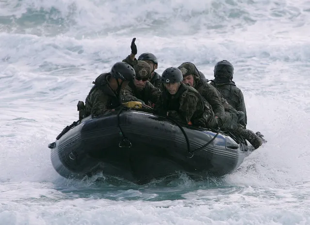 Soldiers with the Japan Maritime Self-Defense Force and U.S. Marines land on the beach during a simulated beach assault at Marine Corps Base Hawaii with the 3rd Marine Expeditionary Unit during the multi-national military exercise RIMPAC in Kaneohe, Hawaii, July 30, 2016. (Photo by Hugh Gentry/Reuters)