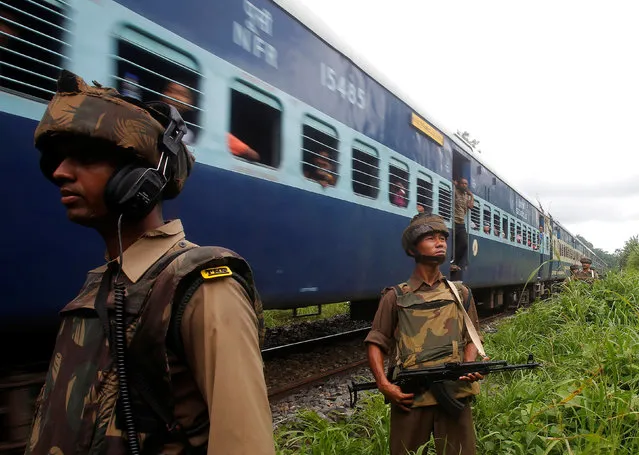 Indian paramilitary soldiers patrol next to a passing train ahead of the country's Independence Day celebrations on the outskirts of Agartala, India, August 12, 2016. (Photo by Jayanta Dey/Reuters)