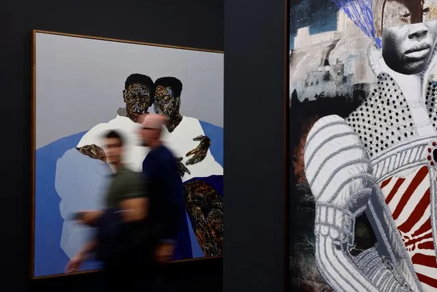Visitors walk past artwork pieces displayed by Mariane Ibrahim gallery as Paris+ par Art Basel international contemporary art fair opens in Paris, France on October 19, 2022. (Photo by Christian Hartmann/Reuters)
