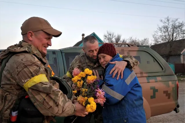 Local resident Valentyna Buhaiova embraces Ukrainian marines in the recently retaken village of Kyselivka, outside of Kherson, Ukraine on November 12, 2022. (Photo by Valentyn Ogirenko/Reuters)