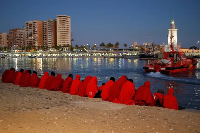 Migrants, part of a group intercepted aboard a dinghy off the coast in the Mediterranean Sea, rest after arriving on a rescue boat at the Port of Malaga, Spain on December 7, 2017. (Photo by Jon Nazca/Reuters)