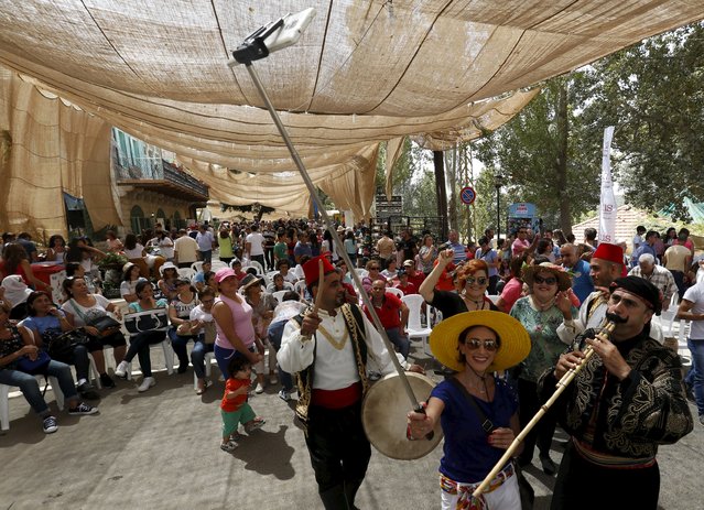A woman takes a selfie with a traditional musical group during a traditional dance festival held in Maaser al Shouf village in Mount Lebanon September 13, 2015. (Photo by Jamal Saidi/Reuters)