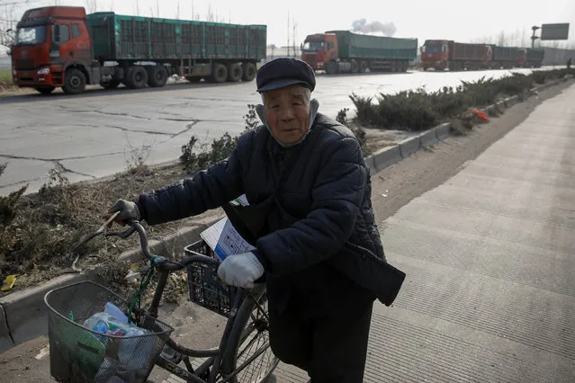 A man collecting recyclables pushes a bicycle past trucks that are parked outside ceramics factories in rural Gaoyi county near Shijiazhuang, Hebei province, China, December 7, 2017. (Photo by Thomas Peter/Reuters)