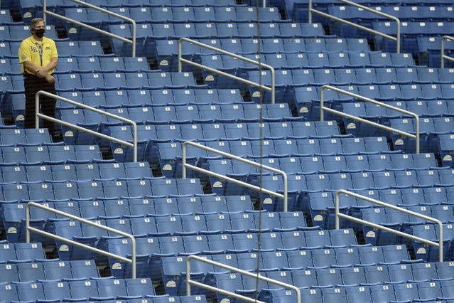 A security guards stands watch over empty seats during the fourth inning of a baseball game between the Tampa Bay Rays and the Toronto Blue Jays Sunday, July 26, 2020, in St. Petersburg, Fla. There are no fans allowed in the stadium to help stop the spread of the corona virus. (Photo by Chris O'Meara/AP Photo)