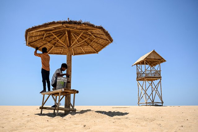 Workers install temporary shelter for shade at Marina Beach on a hot summer day in Chennai on June 4, 2025. (Photo by R. Satish Babu/AFP Photo)